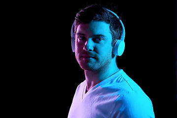 Image showing man in headphones over neon lights of night club