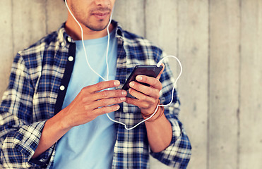 Image showing man with earphones and smartphone listening music