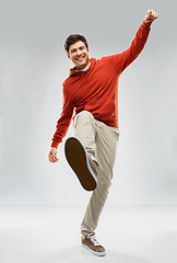 Image showing happy young man in hoodie stepping up