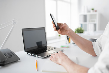 Image showing businessman using smartphone at office