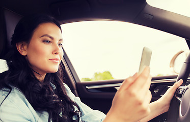 Image showing happy woman driving car with smarhphone