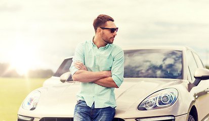 Image showing happy man standing at car outdoors