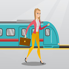 Image showing Young woman walking on a railway station platform.