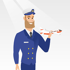 Image showing Cheerful airline pilot with the model of airplane.