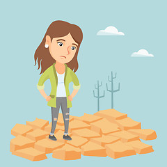 Image showing Sad woman standing on cracked earth in the desert.