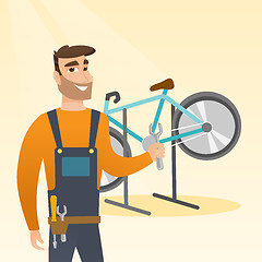 Image showing Caucasian bicycle mechanic working in repair shop.