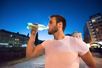 Image showing man drinking water after running session