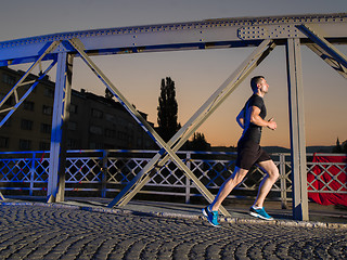 Image showing man jogging across the bridge in the city