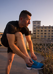 Image showing man tying running shoes laces