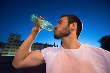 Image showing man drinking water after running session