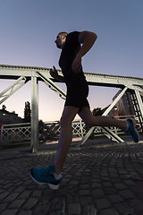 Image showing man jogging across the bridge in the city