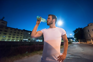 Image showing man drinking water after running session