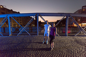 Image showing couple jogging across the bridge in the city