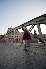 Image showing man jogging across the bridge at sunny morning