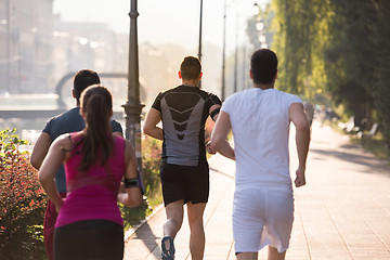 Image showing group of young people jogging in the city