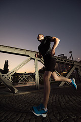 Image showing man jogging across the bridge in the city