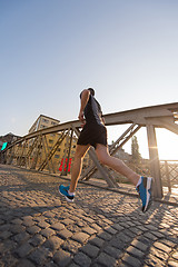 Image showing man jogging across the bridge at sunny morning