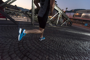 Image showing man jogging across the bridge in the city