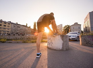 Image showing man tying running shoes laces