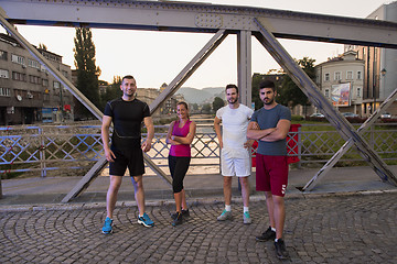 Image showing group of young people jogging across the bridge