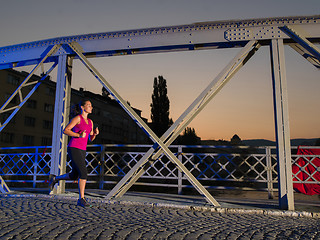 Image showing woman jogging across the bridge in the city