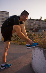 Image showing man tying running shoes laces