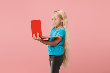 Image showing The happy child with red laptop on pink