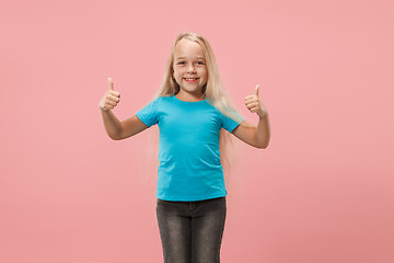 Image showing The happy teen girl standing and smiling against pink background.