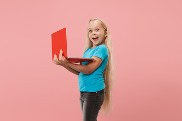 Image showing The happy child with red laptop on pink