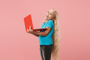 Image showing The happy child with red laptop on pink