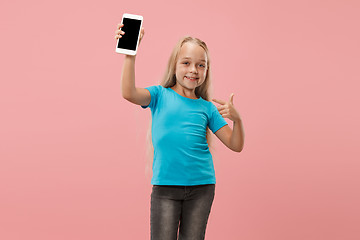 Image showing The happy teen girl standing and smiling against pink background.