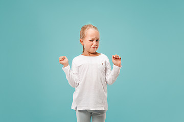 Image showing Doubtful pensive teen girl rejecting something against blue background