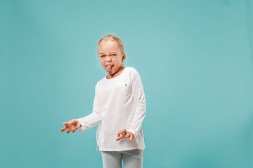 Image showing Doubtful pensive teen girl rejecting something against blue background