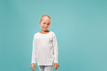 Image showing Doubtful pensive teen girl rejecting something against blue background