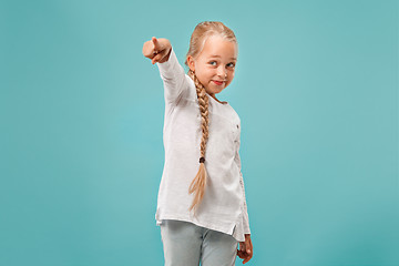 Image showing The happy teen girl pointing to you, half length closeup portrait on blue background.