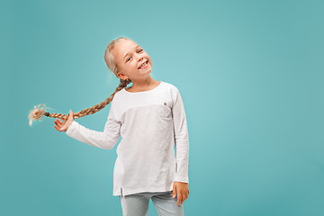 Image showing The happy teen girl standing and smiling against blue background.