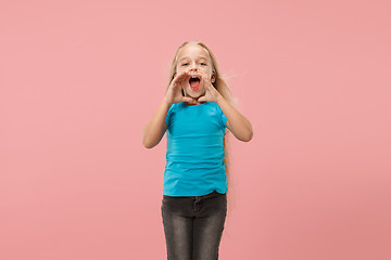 Image showing Isolated on pink young casual teen girl shouting at studio