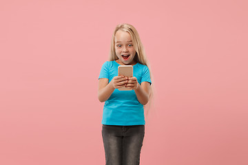 Image showing The happy teen girl standing and smiling against pink background.