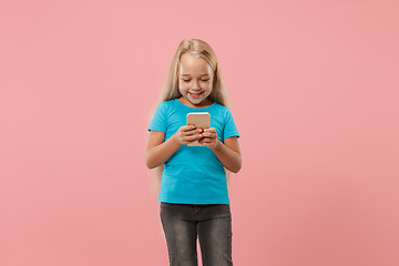 Image showing The happy teen girl standing and smiling against pink background.