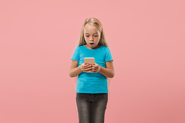 Image showing The happy teen girl standing and smiling against pink background.