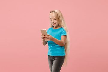 Image showing The happy teen girl standing and smiling against pink background.