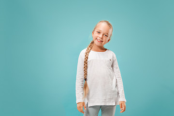 Image showing The happy teen girl standing and smiling against blue background.