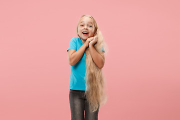 Image showing The happy teen girl standing and smiling against pink background.