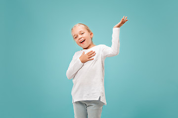 Image showing The happy teen girl standing and smiling against blue background.