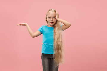 Image showing The happy teen girl standing and smiling against blue background.