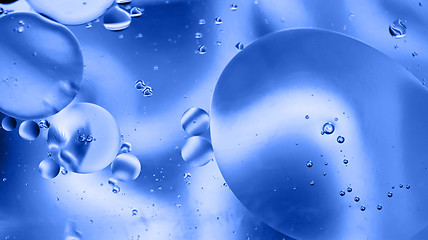 Image showing Defocused abstract background picture made with oil, water and soap. Blue toned.