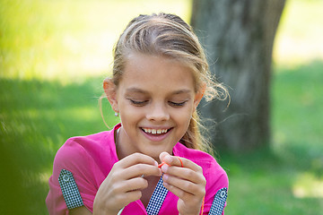 Image showing Portrait of a girl who knits on a knitting needles on a picnic in nature, close-up