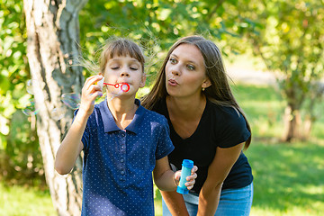 Image showing Girl and girl blow bubbles together