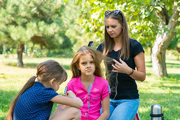 Image showing Girl can not comb the hair of a child