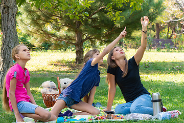 Image showing Family on a picnic saw something on a tree and looks up